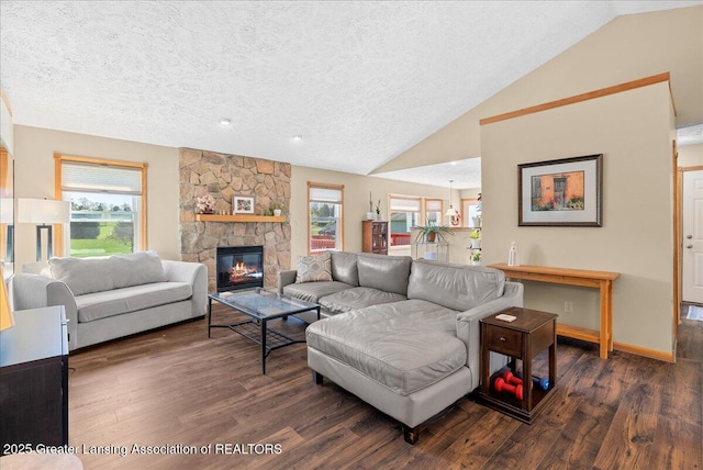 living area with a textured ceiling, a stone fireplace, baseboards, wood finished floors, and lofted ceiling