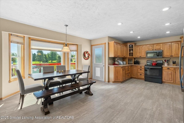 kitchen featuring black electric range oven, glass insert cabinets, recessed lighting, light countertops, and stainless steel microwave
