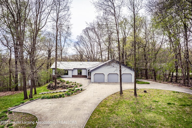 ranch-style house with driveway, a front lawn, and a garage
