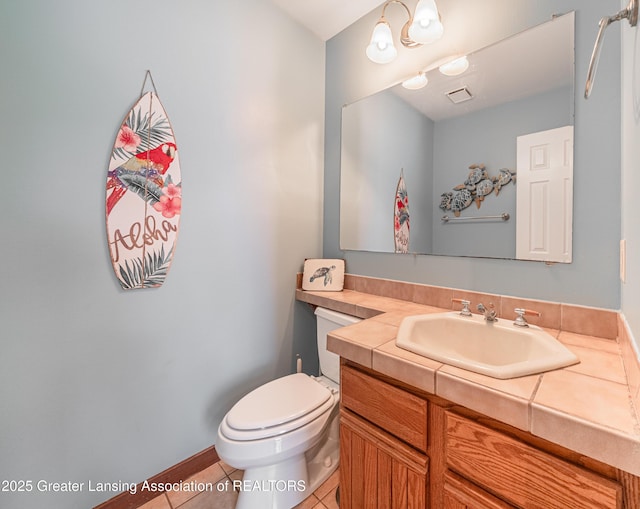 half bathroom with tile patterned flooring, vanity, toilet, baseboards, and visible vents
