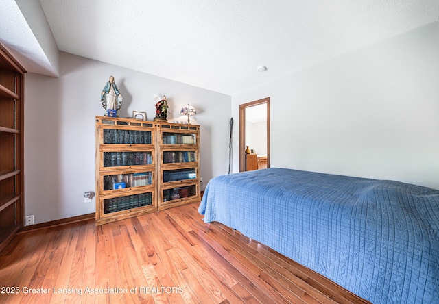 bedroom featuring baseboards and hardwood / wood-style flooring