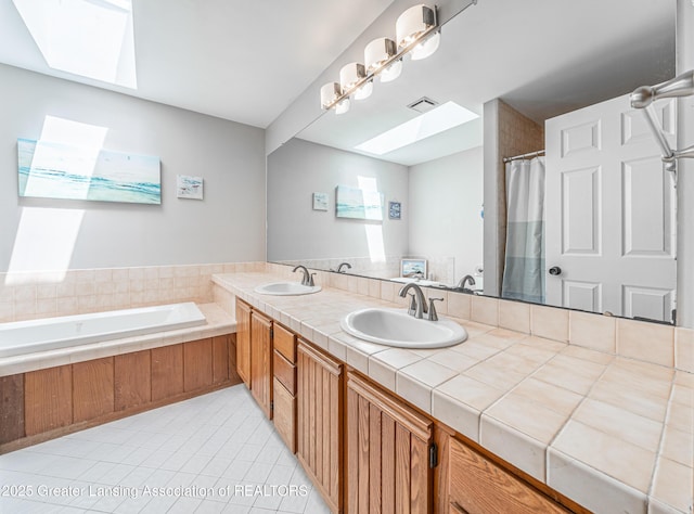 full bathroom with a skylight, tile patterned flooring, a sink, and visible vents