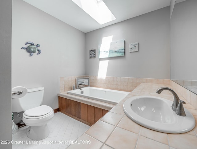 full bathroom with a bath, a skylight, tile patterned flooring, a sink, and toilet