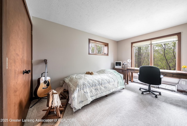 carpeted bedroom featuring a textured ceiling and multiple windows