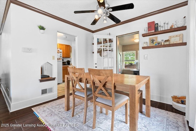 dining room with visible vents, ornamental molding, baseboards, ceiling fan, and light wood-type flooring