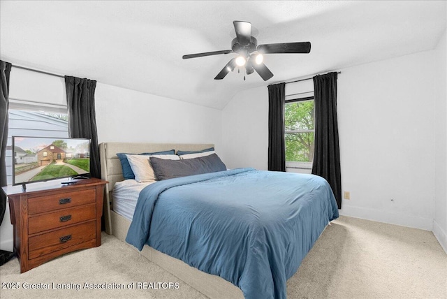 bedroom with baseboards, a ceiling fan, vaulted ceiling, and light colored carpet