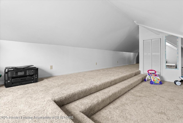additional living space with vaulted ceiling, baseboards, and carpet flooring
