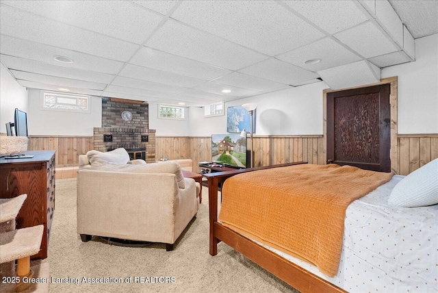 bedroom featuring carpet flooring, wainscoting, a paneled ceiling, and a fireplace