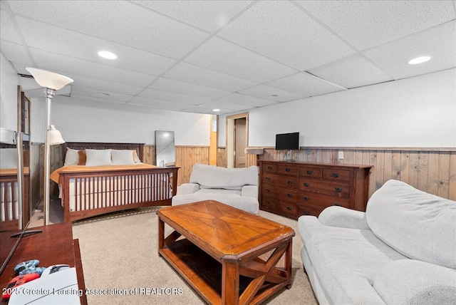 bedroom featuring wood walls, wainscoting, a drop ceiling, recessed lighting, and carpet