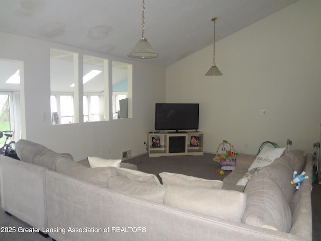carpeted living area with visible vents and lofted ceiling