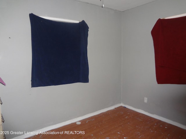unfurnished room featuring baseboards and wood finished floors