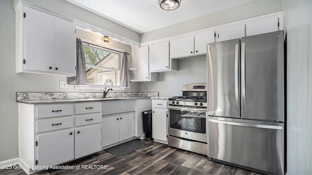 kitchen featuring dark wood-type flooring, light countertops, white cabinetry, and stainless steel appliances