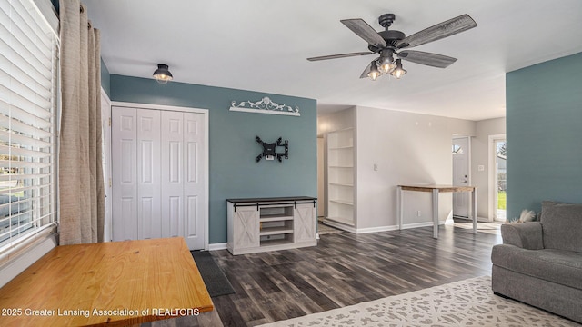 living room featuring baseboards, ceiling fan, and wood finished floors
