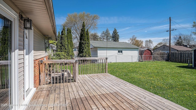 wooden deck with a fenced backyard, an outdoor structure, and a yard