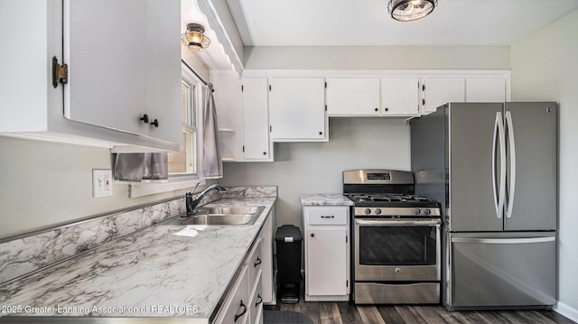 kitchen with a sink, white cabinets, stainless steel appliances, and dark wood-style flooring
