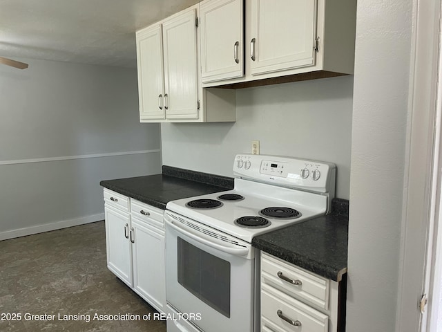 kitchen with white range with electric cooktop, dark countertops, and white cabinetry
