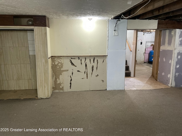unfinished basement featuring carpet floors and stairway