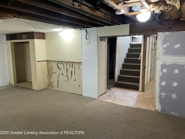 unfinished below grade area with carpet flooring and stairway