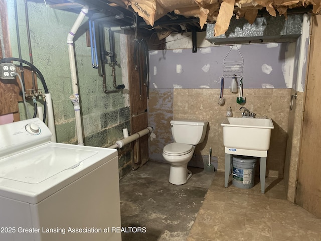 bathroom featuring washer / dryer and toilet