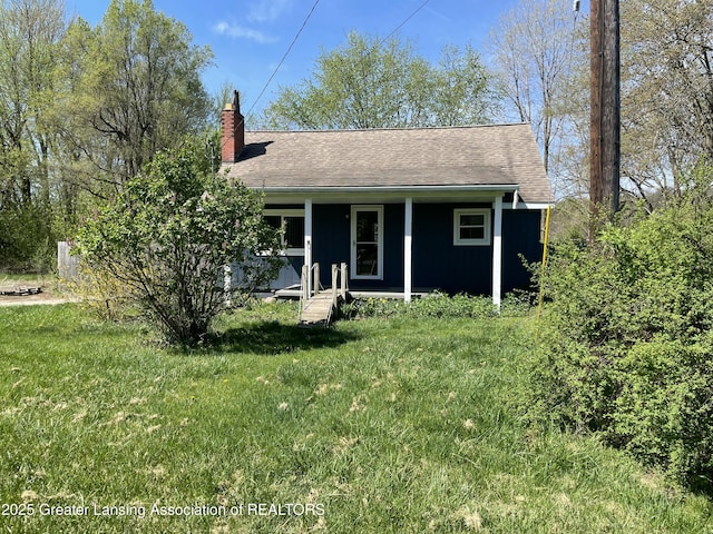 bungalow-style home with covered porch, a chimney, and a front yard