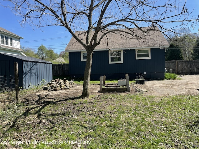 view of yard featuring fence and an outbuilding