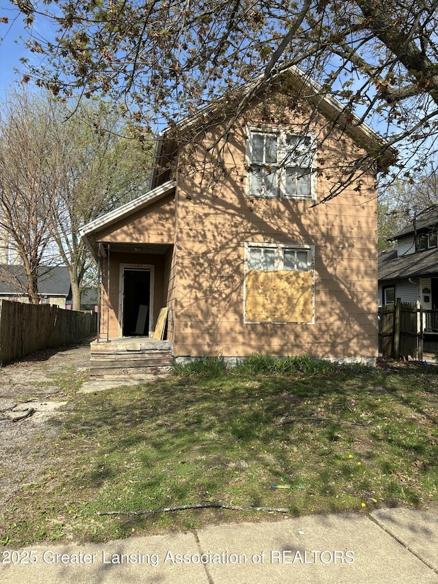 exterior space with fence and a lawn