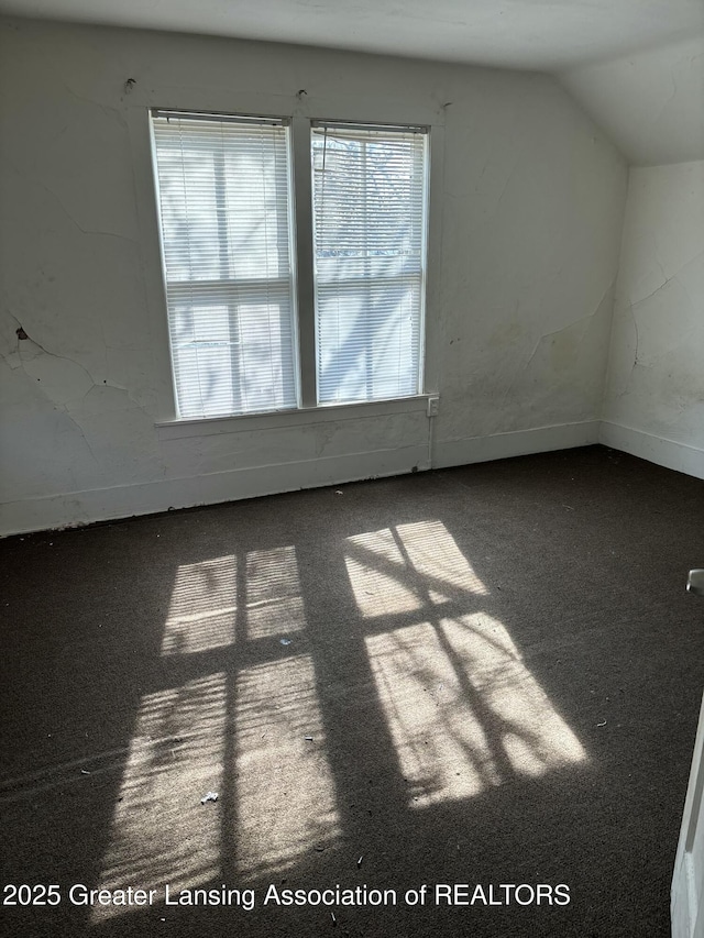 interior space with carpet floors and vaulted ceiling