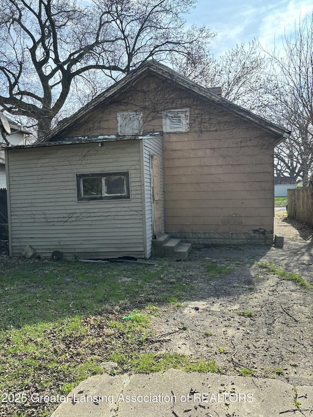 view of side of home with fence and entry steps