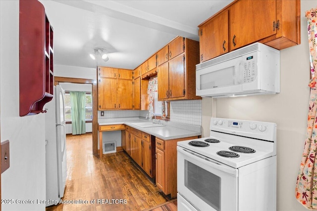 2035 Mary Ave, Lansing, MI 48910 - kitchen featuring visible vents, a sink, light countertops, dark wood-style floors, and white appliances