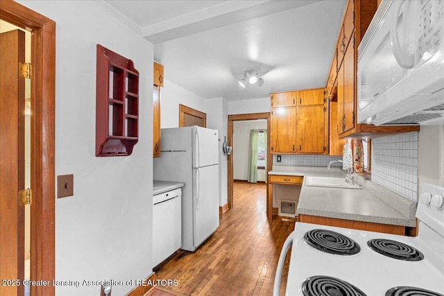 2035 Mary Ave, Lansing, MI 48910 - kitchen with tasteful backsplash, wood finished floors, a sink, light countertops, and white appliances