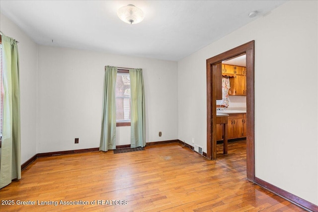 2035 Mary Ave, Lansing, MI 48910 - empty room with baseboards, visible vents, and light wood finished floors
