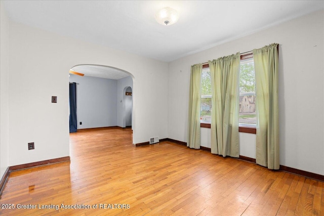 2035 Mary Ave, Lansing, MI 48910 - spare room with visible vents, arched walkways, baseboards, and light wood-type flooring