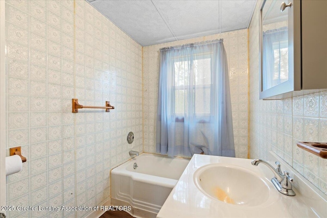 2035 Mary Ave, Lansing, MI 48910 - full bathroom featuring a tub, tile walls, vanity, and a textured ceiling