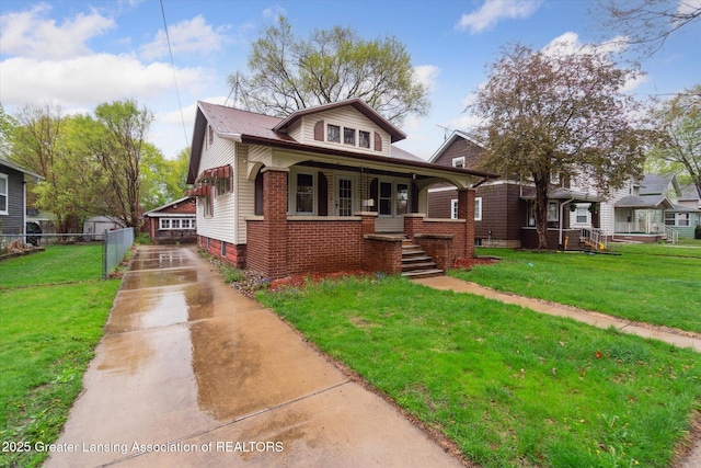 bungalow with a front lawn, fence, covered porch, and concrete driveway