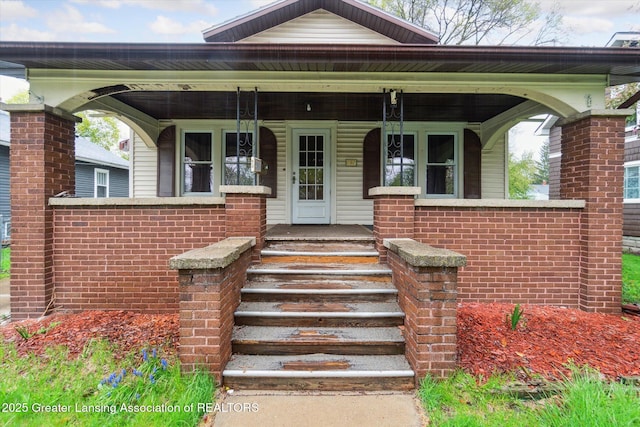 view of front of home featuring brick siding and covered porch