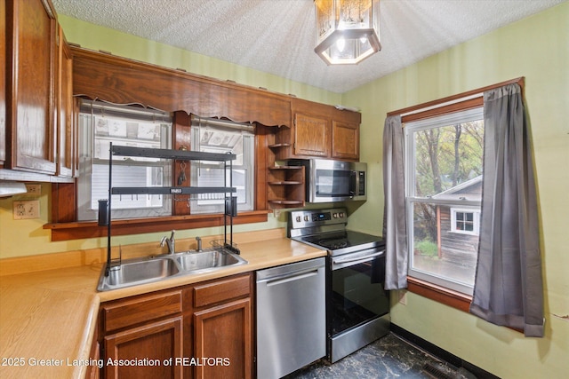 kitchen with light countertops, stainless steel appliances, brown cabinets, and a sink