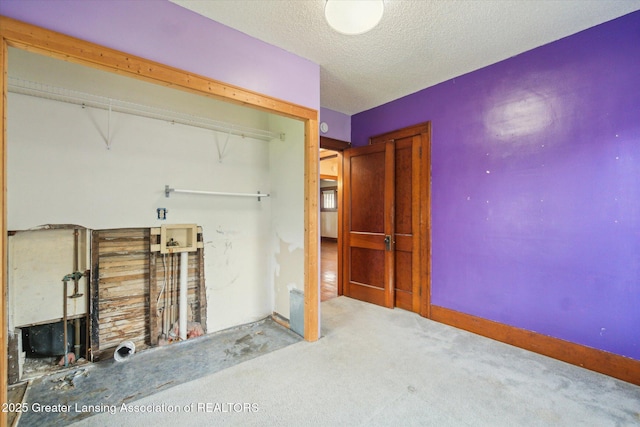 interior space with a textured ceiling, laundry area, and carpet