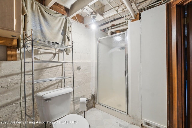 bathroom featuring a shower stall, toilet, and visible vents