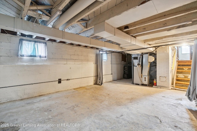 below grade area with stairs, heating unit, and a wealth of natural light