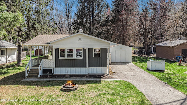 111 Terrace Dr, Houghton Lake, MI 48629 - view of shed featuring a fire pit and asphalt driveway
