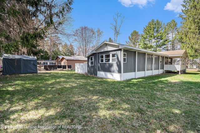 111 Terrace Dr, Houghton Lake, MI 48629 - view of side of property featuring board and batten siding, a yard, and a sunroom