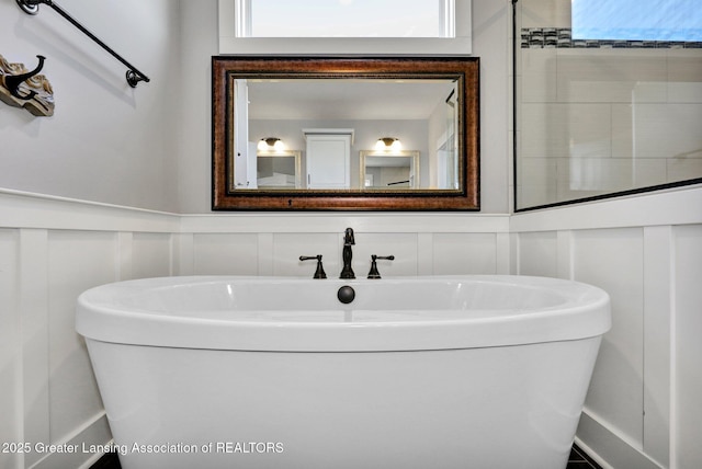 bathroom featuring a wainscoted wall and a decorative wall