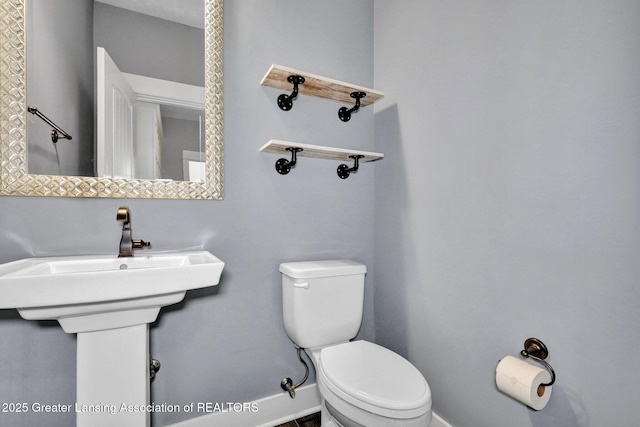 bathroom featuring baseboards and toilet