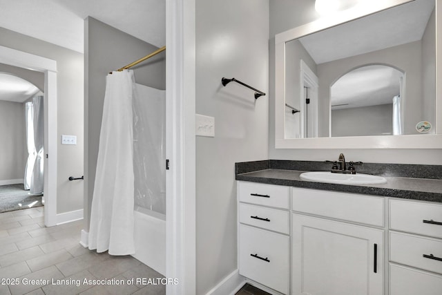 full bath with baseboards, tile patterned flooring, shower / tub combo, and vanity