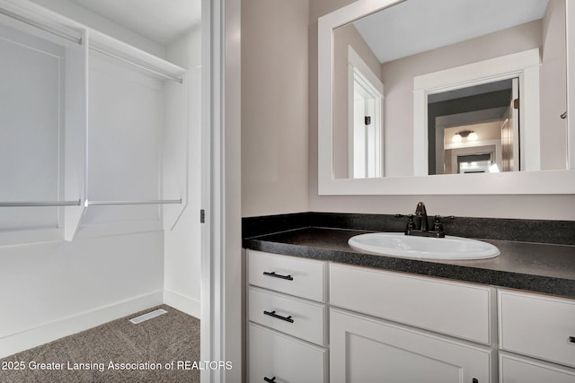 bathroom featuring visible vents, baseboards, and vanity