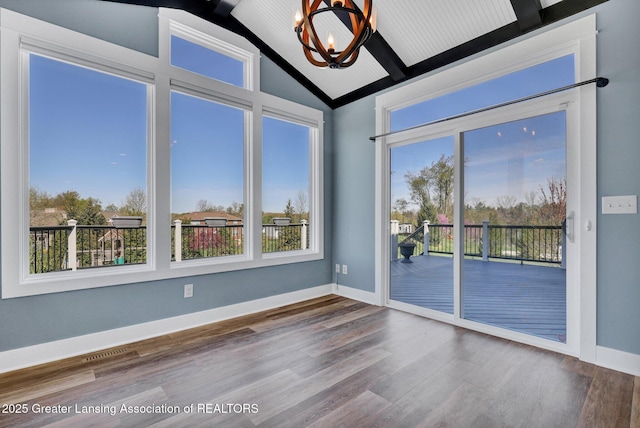 empty room with visible vents, lofted ceiling with beams, a chandelier, and a healthy amount of sunlight