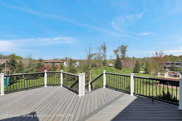 wooden terrace featuring a lawn and a residential view