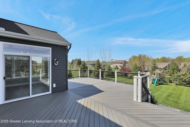 wooden deck featuring a lawn and a playground