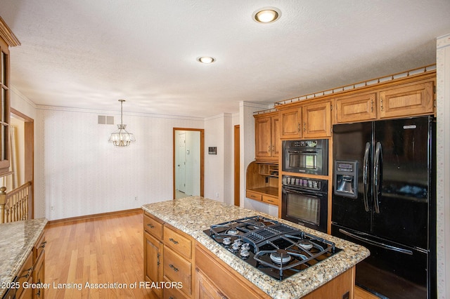 3796 Viceroy Dr, Okemos, MI 48864 - kitchen with black appliances, baseboards, light wood-style floors, a center island, and light stone counters