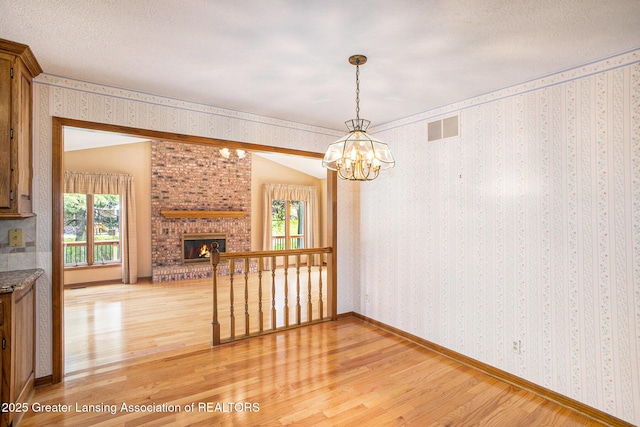 3796 Viceroy Dr, Okemos, MI 48864 - unfurnished dining area featuring light wood finished floors, plenty of natural light, a chandelier, and wallpapered walls